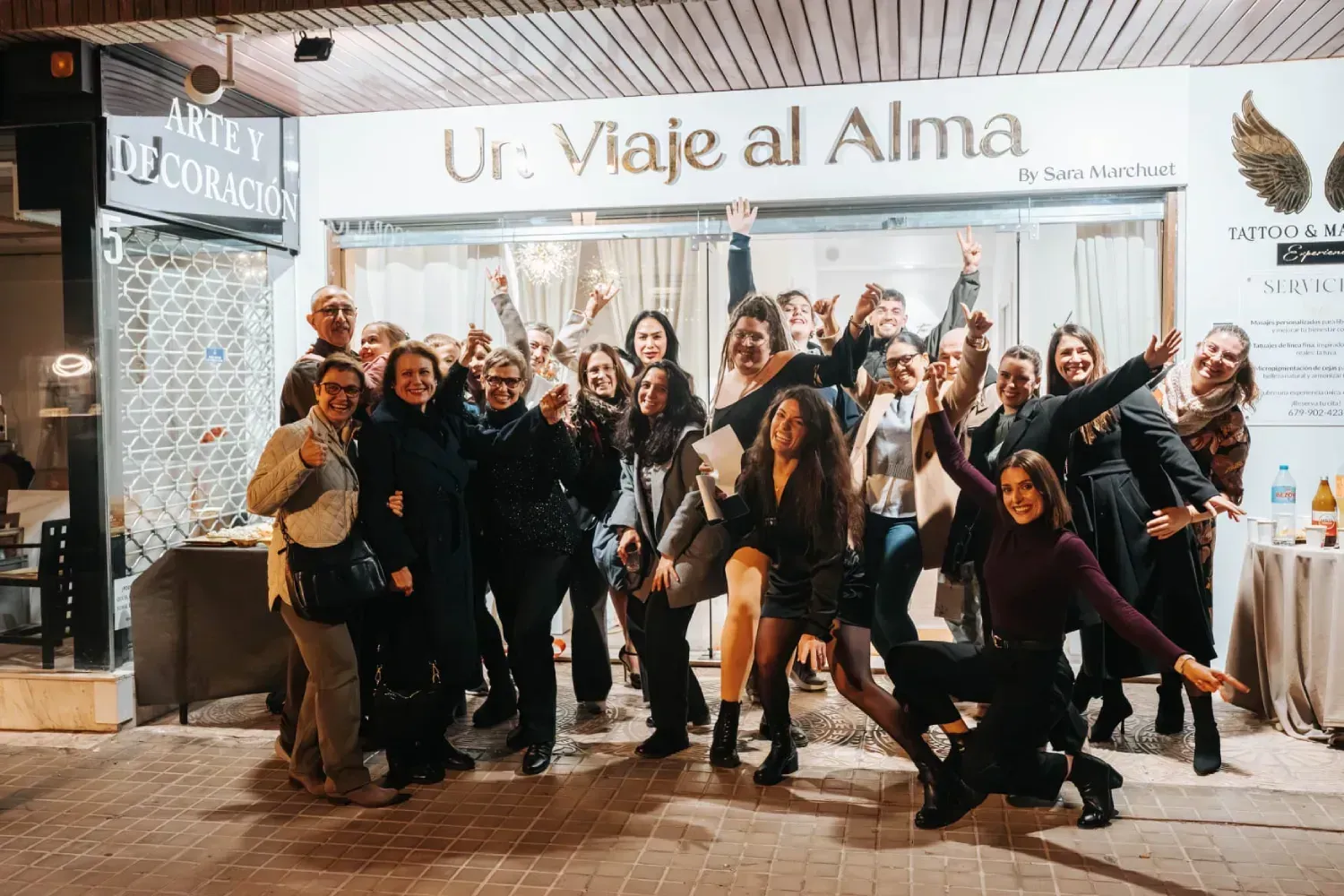 Grupo de personas sonriendo frente a la tienda Un Viaje al Alma en Valencia.